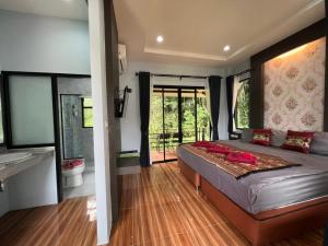 a bedroom with a large bed and a bathroom at Khaosok Rainforest Resort in Khao Sok