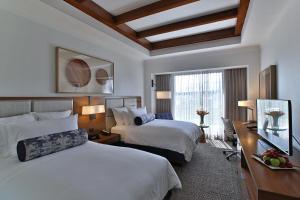 a hotel room with two beds and a television at Real Intercontinental Metrocentro Managua by IHG in Managua