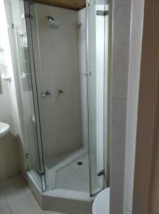 a shower with a glass door in a bathroom at Mirador del parque in Bogotá