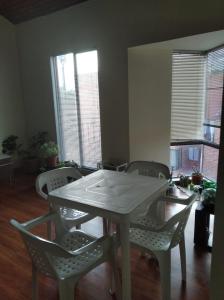 une salle à manger avec une table et des chaises blanches dans l'établissement Mirador del parque, à Bogotá