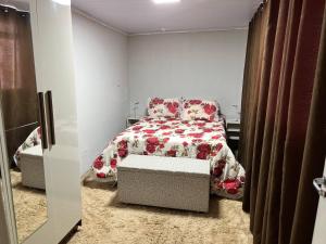 1 Schlafzimmer mit einem Bett mit Blumendecke in der Unterkunft Linda Casa 3 qts prox JK Shopping in Brasilia