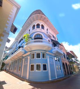 ein blaues Gebäude mit Balkon auf einer Straße in der Unterkunft Magnolia Inn in Panama-Stadt