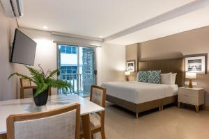 ein Schlafzimmer mit einem Bett und einem Tisch sowie ein Esszimmer in der Unterkunft Apartamentos casa Gimani in Cartagena de Indias