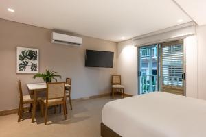 um quarto com uma cama, uma mesa e uma televisão em Apartamentos casa Gimani em Cartagena das Índias