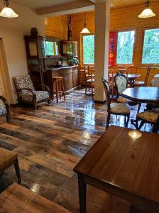 a living room with wooden floors and tables and chairs at Kincs Apartman és Jurtaszállás in Dobogoko