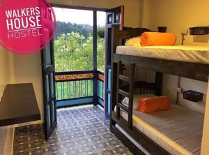 a room with two bunk beds and a balcony at Walker's House Hostel in Salento