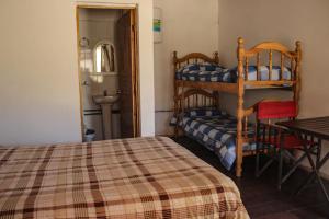 a bedroom with a bed and a bunk bed and a table at Altas Cumbres Penitentes in Los Penitentes