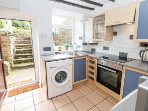 eine Küche mit Waschmaschine und Spüle in der Unterkunft Beas Cottage in Highpeak Junction + 12 Fotos