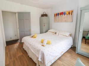 Un dormitorio con una cama con almohadas amarillas. en Beas Cottage, en Highpeak Junction