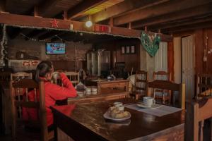 a woman talking on a cell phone in a kitchen at Altas Cumbres Penitentes in Los Penitentes