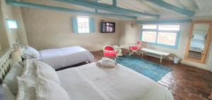 1 Schlafzimmer mit 2 Betten, einem Tisch und 2 Stühlen in der Unterkunft Casa Provenzal in Villa de Leyva