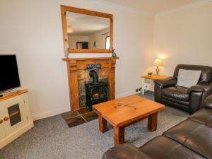 a living room with a fireplace and a couch and a table at Raygill Cottage in Whitby