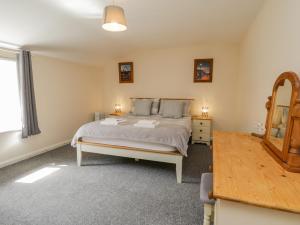 a bedroom with a bed and a dresser and a mirror at Raygill Cottage in Whitby