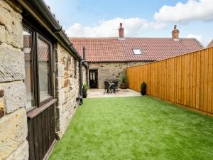 an internal courtyard of a house with a green lawn at Raygill Cottage in Whitby