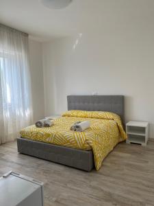 Un dormitorio con una cama grande con una manta amarilla. en Maison Merci, en Pedemonte