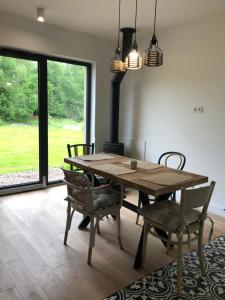 a dining room with a wooden table and chairs and a fireplace at Calma House Ublik in Wyszowate