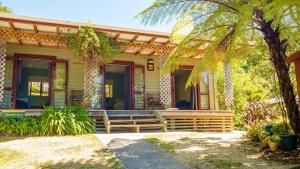 ein Haus mit einer Bank auf der Vorderseite in der Unterkunft Hopewell Lodge in Kenepuru Sounds