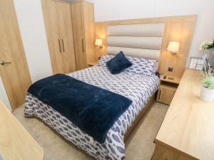 a bedroom with a bed with a blue blanket on it at Chantry Lodge in Newquay