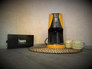 a blender sitting on a counter next to two cups at Residenza Airone Bianco in Ronchi dei Legionari