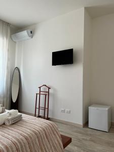 una camera con un letto e una televisione a muro di Maison Merci a Pedemonte