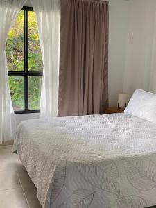 a bedroom with a large bed and a window at Pequeño Paraíso 2 in El Placer
