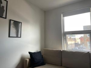 a living room with a couch and a large window at Bethnal Cove in London