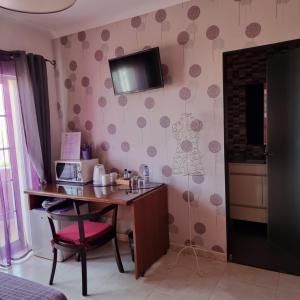 a room with a desk and a microwave on a wall at Casa Dos Cedros in Lagos