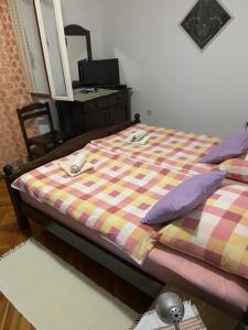 a bedroom with a bed with a checkered blanket at Rooms Juran in Sukošan