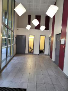 an empty hallway of an office building with lights at III Appart 2 Pièces, Neuf 200 m de Gare Parking Netflix Evry Courcouronnes in Evry-Courcouronnes