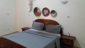 ein Schlafzimmer mit einem Bett mit zwei Uhren an der Wand in der Unterkunft Villa chez Julien in Rufisque