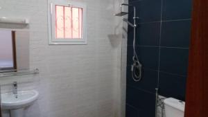 a bathroom with a sink and a toilet and a window at Villa Julien 2 chambres in Rufisque +11 photos