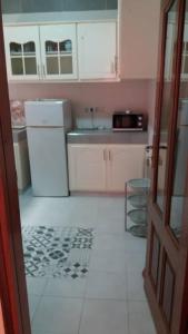a kitchen with a white refrigerator and a sink at Villa chez Julien in Rufisque