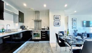 a kitchen with a table and a dining room at Artistic and luxurious APT with Sea view. Beach side in Swansea