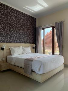 a bedroom with a large bed and a window at North Wing Canggu Resort in Dalung