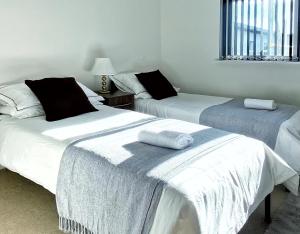 a room with two beds with towels on them at Artistic and luxurious APT with Sea view. Beach side in Swansea
