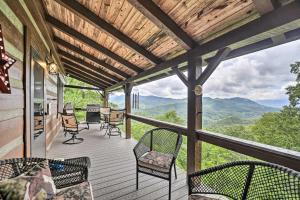 a porch with chairs and a table and a view of mountains at Bryson City Cabin with Hot Tub about 10 Mi to Dtwn! in Lauada