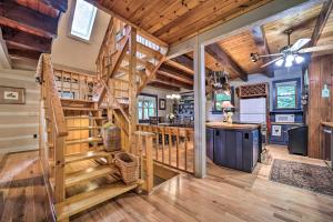 a kitchen and living room with a spiral staircase in a log home at Bryson City Cabin with Hot Tub about 10 Mi to Dtwn! in Lauada