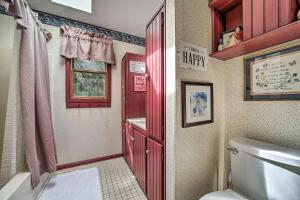 a bathroom with a toilet and a red door at Bryson City Cabin with Hot Tub about 10 Mi to Dtwn! in Lauada +31 photos