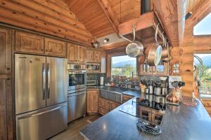 a kitchen with wooden cabinets and a stainless steel refrigerator at Stunning Driggs Retreat with Private Hot Tub and Pond! in Driggs