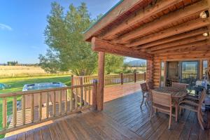 a wooden deck with a table and chairs on it at Stunning Driggs Retreat with Private Hot Tub and Pond! in Driggs