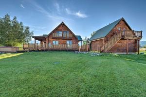 a large yard in front of a log house at Stunning Driggs Retreat with Private Hot Tub and Pond! in Driggs