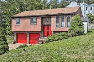 a house with red garage doors on a hill at Pittsburgh Retreat with Deck about 4 Mi to Dtwn! in Pittsburgh