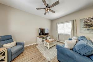 a living room with a blue couch and a ceiling fan at Leeward Isles 207 in Padre Island