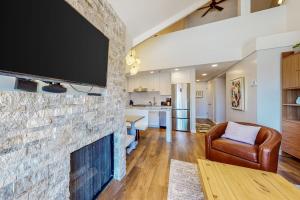 uma sala de estar com uma lareira de pedra e uma televisão de ecrã plano em Majestic Mountain Village Getaway em Park City