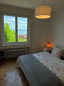 a bedroom with a bed and a large window at Alpes Rez in Neuchâtel