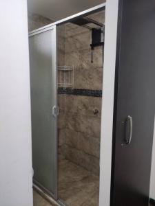 a shower in a bathroom with a glass door at Zidko Guest House in Ibarra