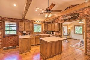 a kitchen with wooden cabinets and a ceiling fan at Norfork Lake Getaway Deck, 6 Mi to Main St! in Mountain Home