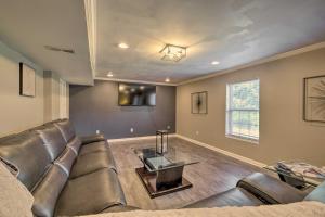 a living room with a leather couch and a table at Cozy Waldorf Guest Suite Near Potomac River! in Waldorf