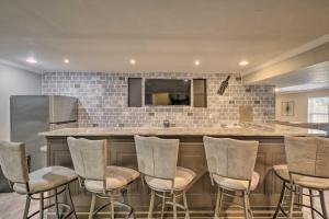 a kitchen with a bar with chairs around it at Cozy Waldorf Guest Suite Near Potomac River! in Waldorf