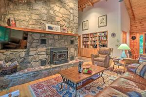 sala de estar con chimenea de piedra y mesa en Tree-Lined Cruso Cabin with Game Room and Mtn Views!, en Canton